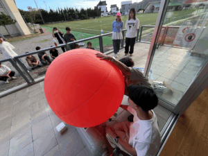 パイロットバルーンにヘリウム注入 (フィールドワークC)